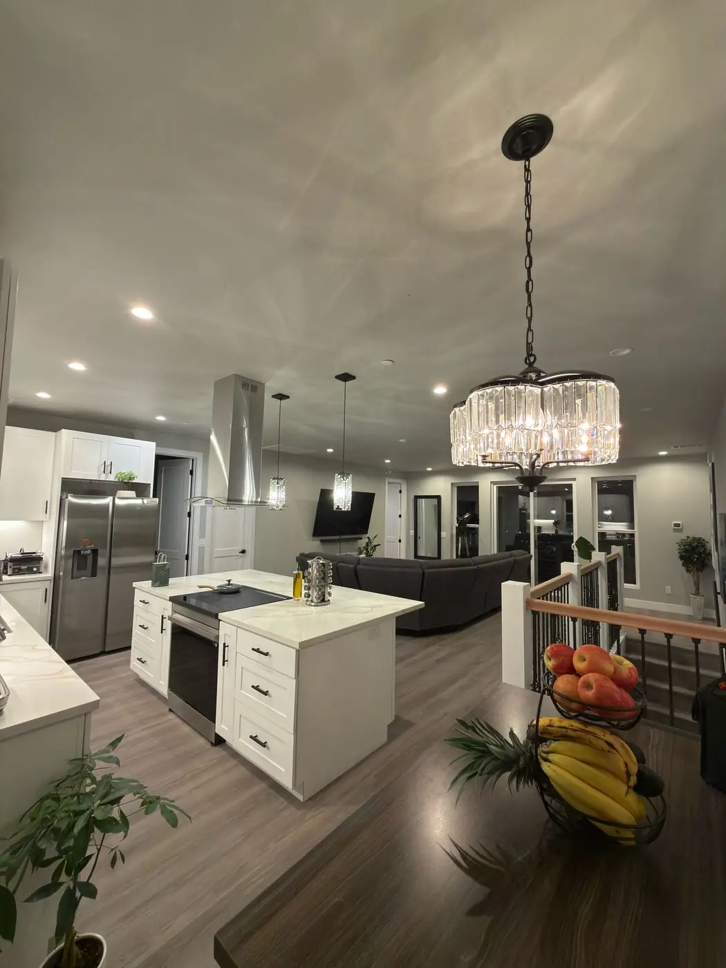 Open kitchen remodel with white cabinets and quartz island